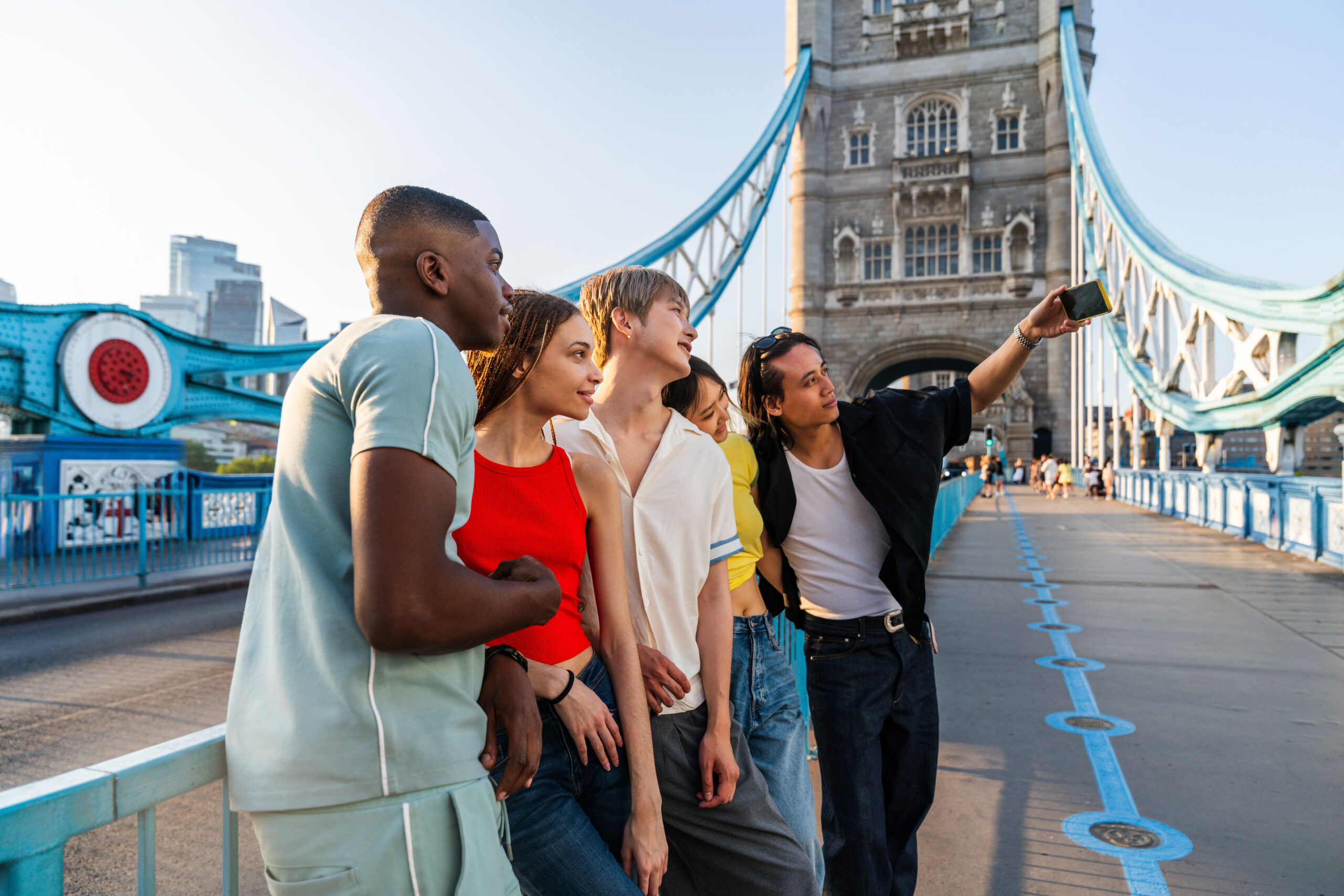 Eine Gruppe junger Menschen auf Sprachreise in London, sie besuchen dabei die Tower Bridge.