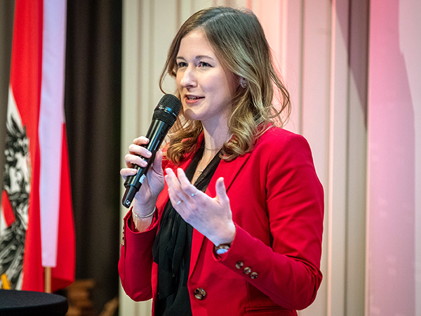 Claudia Plakolm auf der Bühne mit Mikrofon.